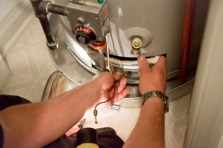 Person working on the bottom of a water heater