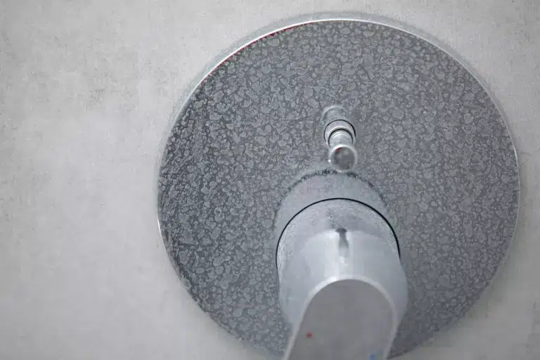 Dirty calcified shower mixer tap, faucet with limescale on it, plaque from water. Chrome-plated shower, close-up photo.