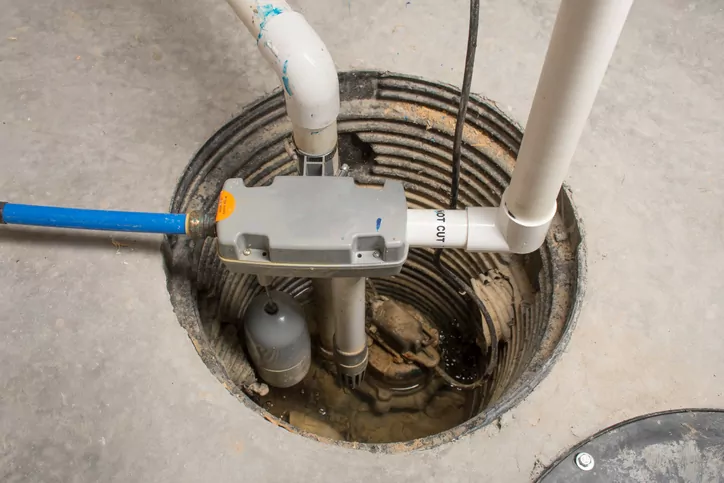 A sump pump installed in the basement of a home with a water-powered backup system.