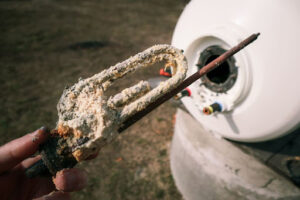 Technician pulling out worn out anode rot from water heater.