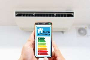 Phone held up in front of indoor AC unit shows energy efficiency ratings.