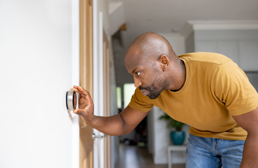 Homeowner adjusting thermostat